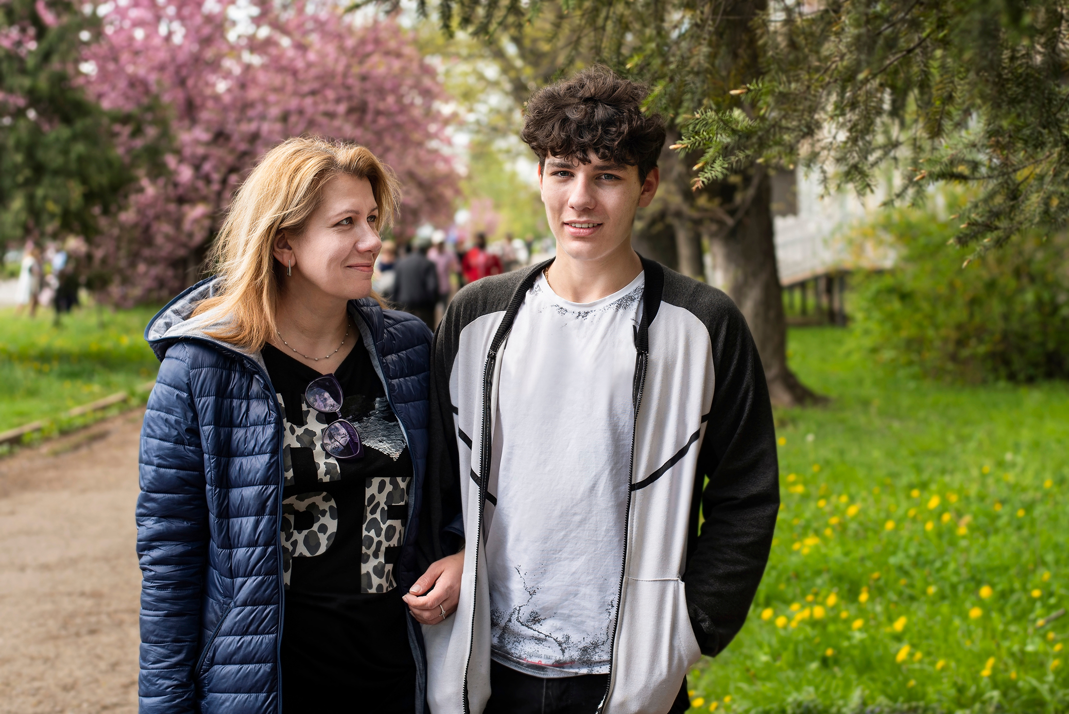 Woman walks with her teenage son and communicate, laugh. A mother looks at her son with love, pride and understanding. The concept of a good relationship between mother and teenage son