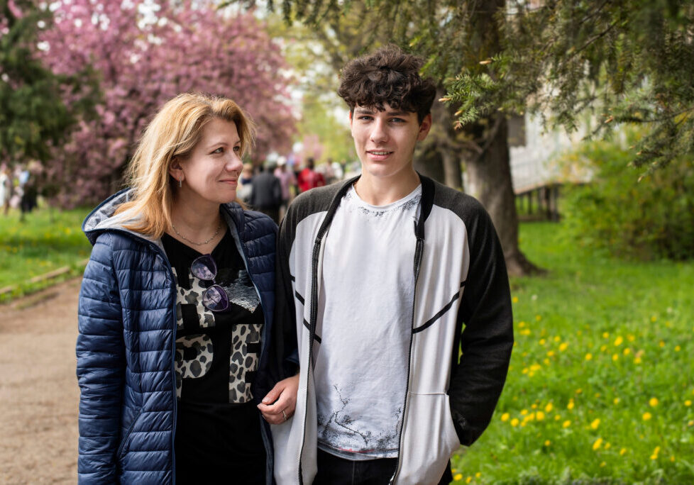 Woman walks with her teenage son and communicate, laugh. A mother looks at her son with love, pride and understanding. The concept of a good relationship between mother and teenage son